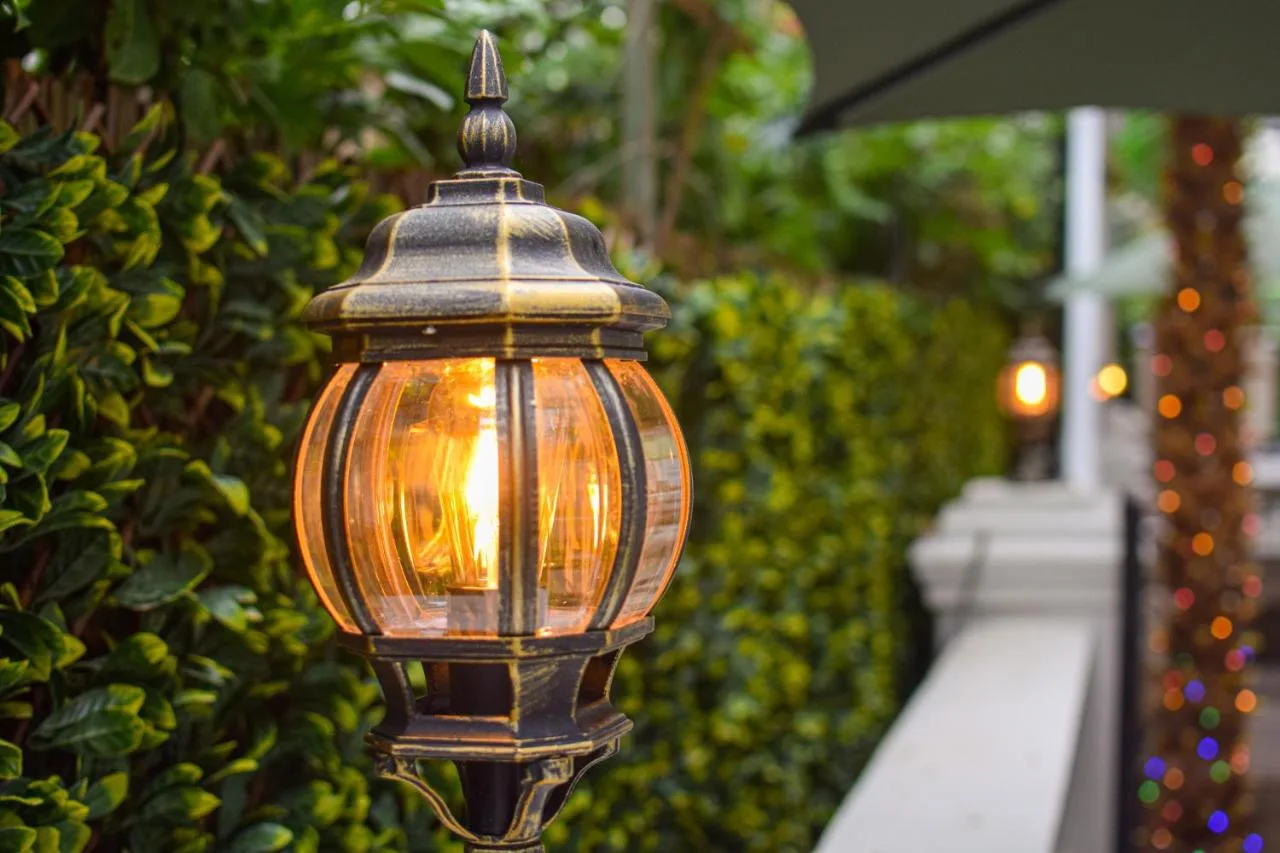 a close up of a street light in front of a hedge at Pembridge Palace Hotel in London